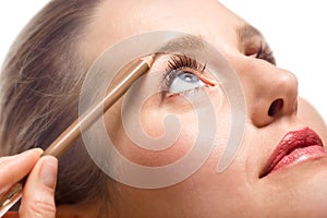 Woman applying make-up using eyebrow pencil