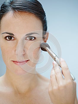 Woman applying makeup with brush