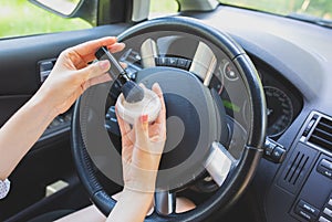 Woman is applying makeup in the car. Girl with face powder behind the wheel. Dangerous situation on the road. Possibility of