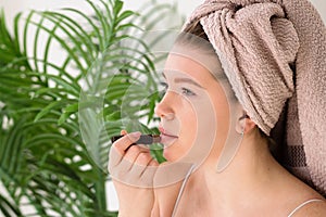 Woman applying makeup with towel wrap