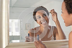 Woman Applying Mascara In Mirror At Home