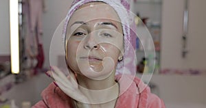 Woman applying mask moisturizing skin cream. Skincare spa. Facial mask