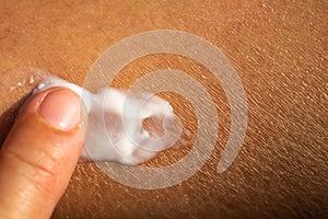 Woman applying moisturising cream on her dry leg, Close up & Macro shot, Asian Body skin part, Healthcare concept, Abstract photo