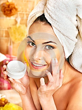 Woman applying moisturizer. photo