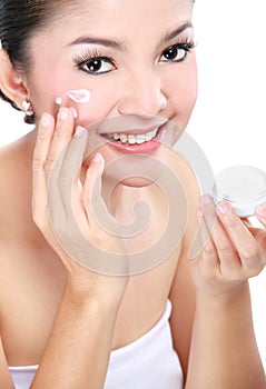 Woman applying moisturizer cream