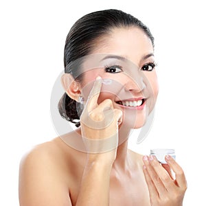 Woman applying moisturizer cream