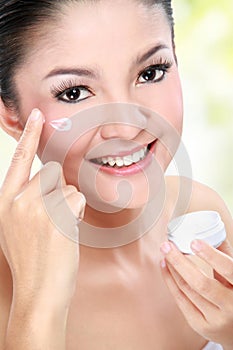 Woman applying moisturizer cream