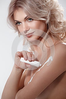 Woman applying moisturizer cream