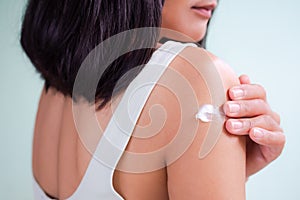 woman applying Moisturizer cream body lotion to hand after bath in home.