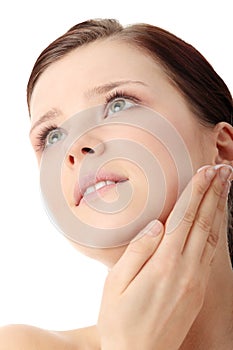 Woman applying moisturizer cream on face