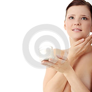 Woman applying moisturizer cream on face