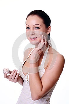 Woman applying moisturizer cream on face. photo