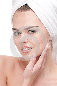 Woman applying moisturizer cream on face