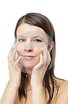 Woman applying moisturizer cream on face