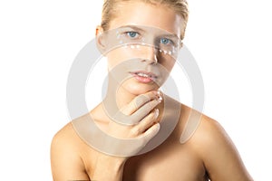 Woman applying moisturizer cream on face isolated