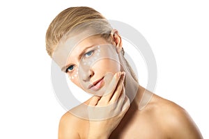 Woman applying moisturizer cream on face isolated