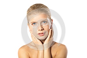 Woman applying moisturizer cream on face isolated