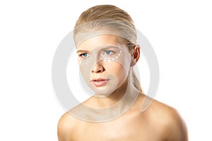 Woman applying moisturizer cream on face isolated