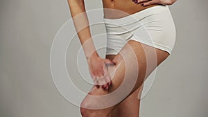 Woman applying moisturizer cream on her leg