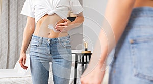 Woman applying moisturizer cream lotion on belly