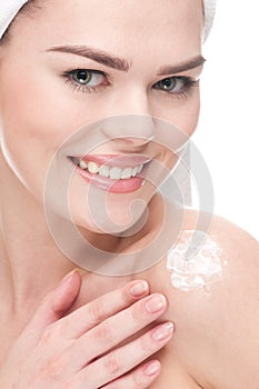 Woman applying moisturizer cream on shoulders