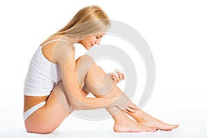 Woman applying moisturizer on leg