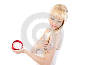 Woman applying moisturizer to her skin