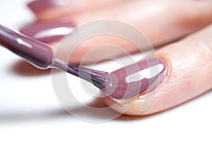 Woman applying nail polish. Beautiful nails. Woman applying polish on nails at home. Pastel nail polish on fingernail. Beauty