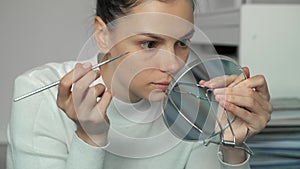 Woman applying paint on eyebrows making beauty procedure at home, closeup view.