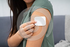 Woman Applying Patch On Her Arm