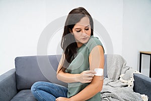 Woman Applying Patch On Her Arm