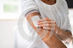 Woman Applying Patch On Her Arm