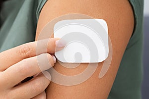 Woman Applying Patch On Her Arm