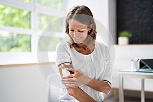 Woman Applying Patch On Her Arm