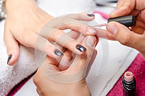 Woman applying pink nail polish