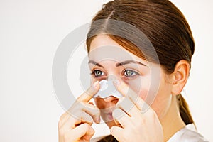 Woman applying pore strips on nose