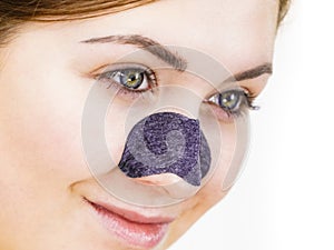 Woman applying pore strips on nose