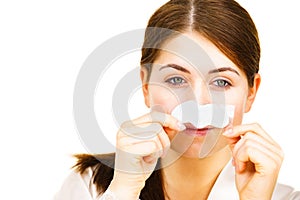 Woman applying pore strips on nose