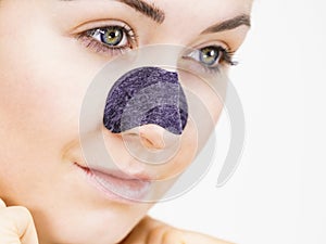 Woman applying pore strips on nose