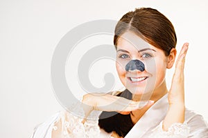 Woman applying pore strips on nose