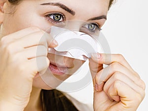 Woman applying pore strips on nose