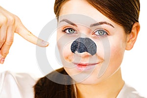 Woman applying pore strips on nose