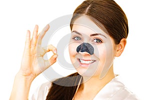 Woman applying pore strips on nose