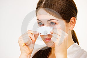 Woman applying pore strips on nose