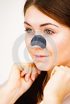 Woman applying pore strips on nose