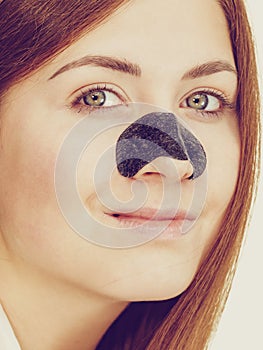 Woman applying pore strips on nose