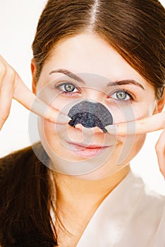 Woman applying pore strips on nose