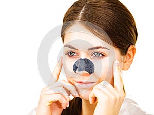 Woman applying pore strips on nose