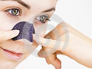 Woman applying pore strips on nose