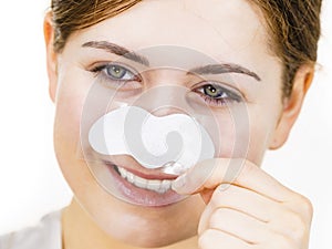 Woman applying pore strips on nose